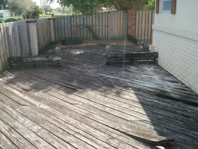 EAST SIDE OF HOME LOOKING SOUTH WITH WOODEN DECK THAT NEEDS TO BE REPLACED