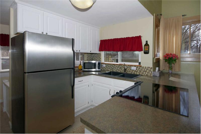 Updated kitchen with stainless steel appliances, tile flooring, composite granite sink, and tile backsplash!