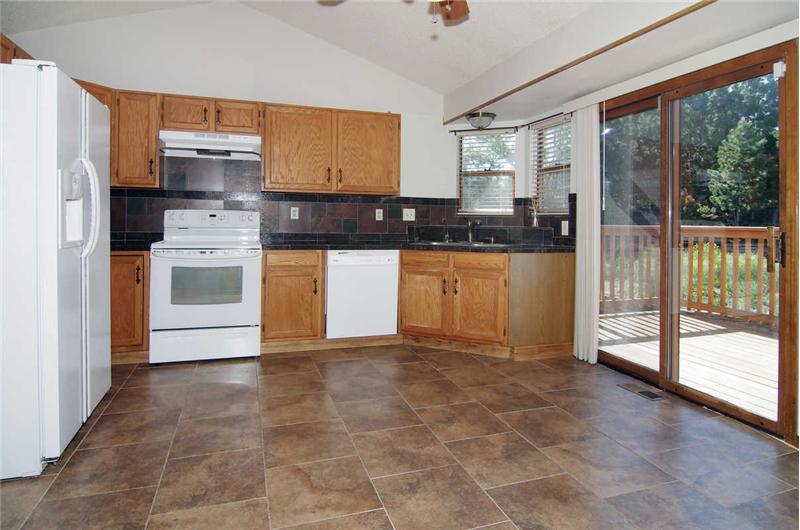 Updated kitchen with granite tile countertops, tile backsplash, and tile flooring. Refrigerator stays...