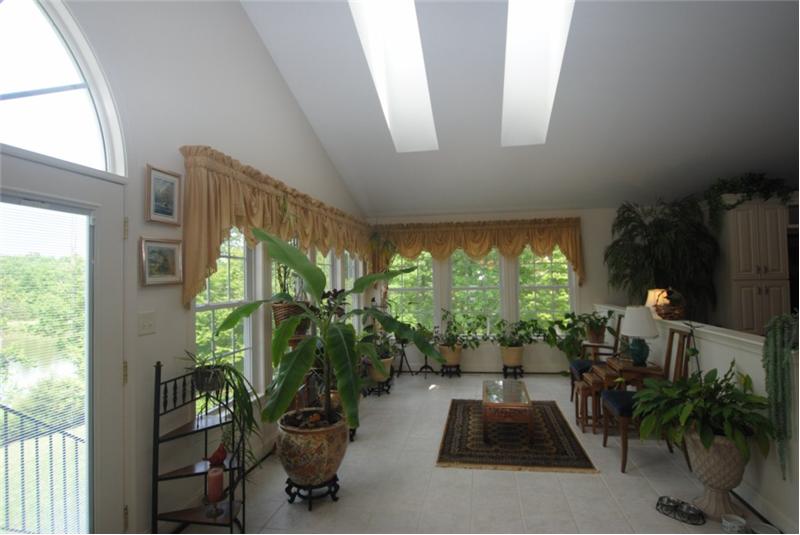 Sunroomm with a wall of windows and skylights