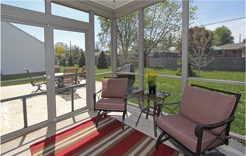 Screened in back porch offers a ceiling fan.