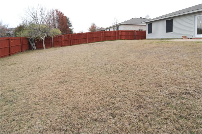 Enjoy privacy with a wooden fence surrounding the back yard.