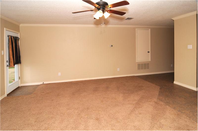 Living room has plenty of space and has a ceiling fan.