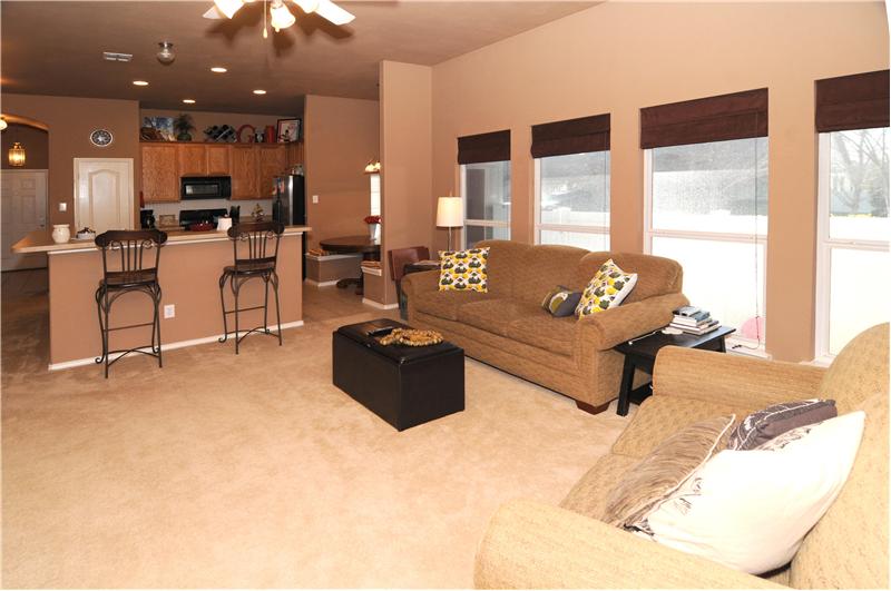 The living space has lots of natural light. Notice the breakfast bar in the kitchen area.