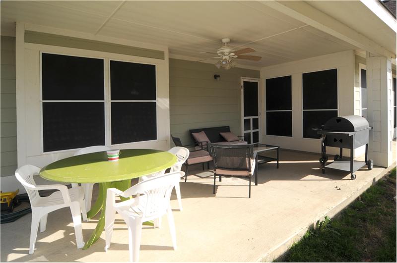 Covered back patio is large and has a ceiling fan. Take note of the solar screens - Save on utility bills!
