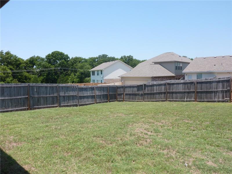 A wood fence surrounds the backyard.