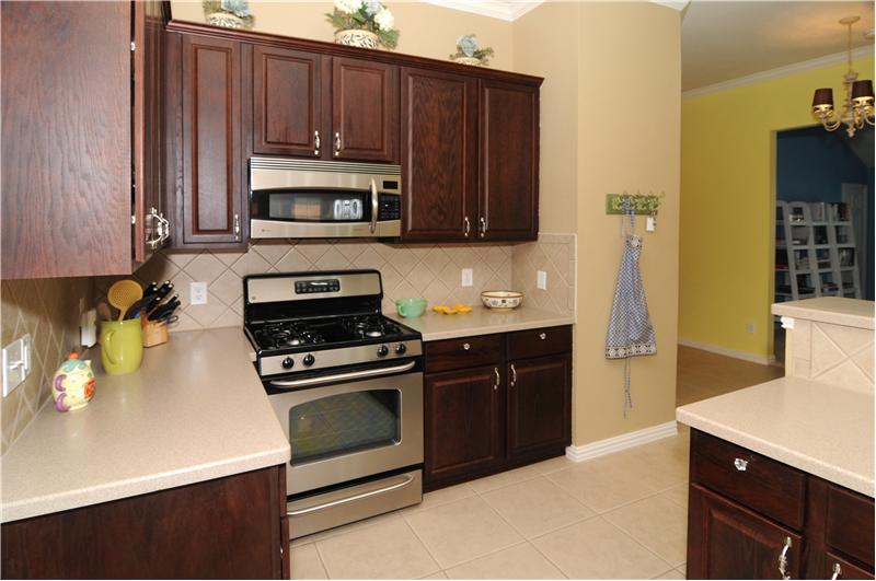 The kitchen has stainless steel appliances, beautiful with the dark cabinets.