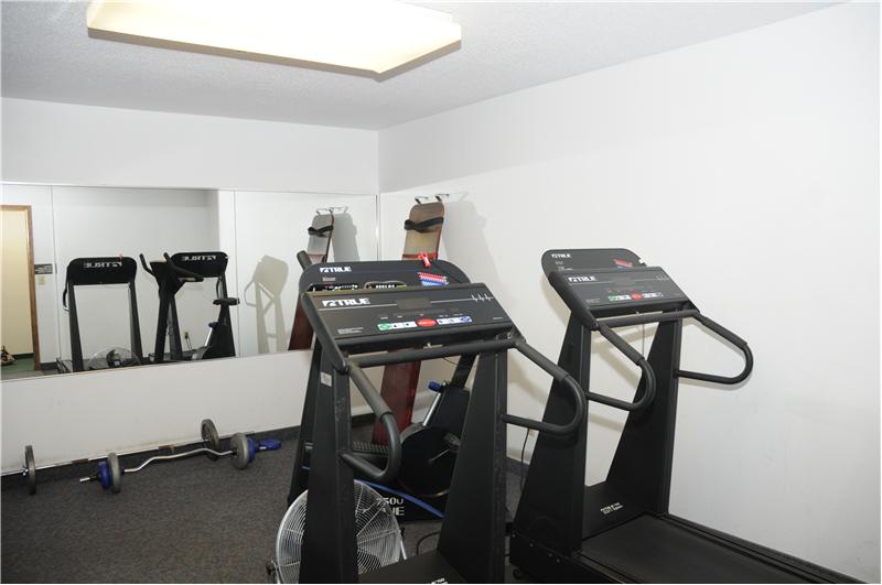Exercise room with wall-mounted TV.