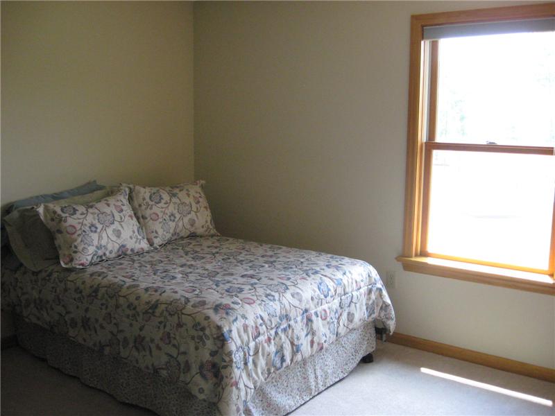 Spacious bedroom with carpeting.