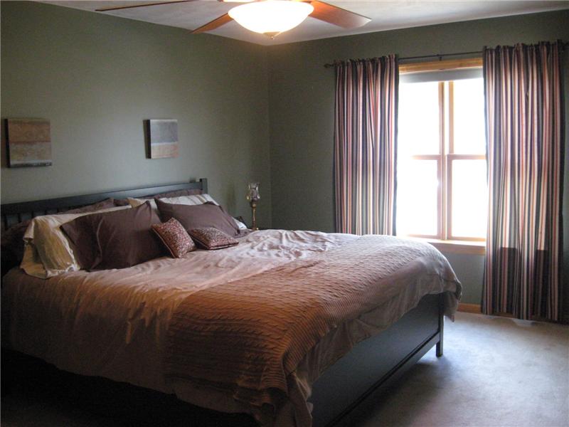 Master bedroom with double windows and a ceiling fan.