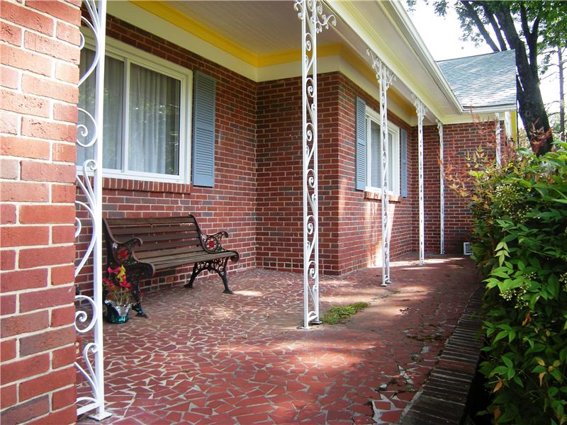 Expansive covered, brick front porch offers a relaxing way to end the day