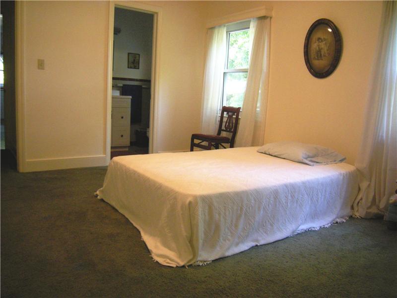 Master bedroom has wall-to-wall carpeting covering wood floors