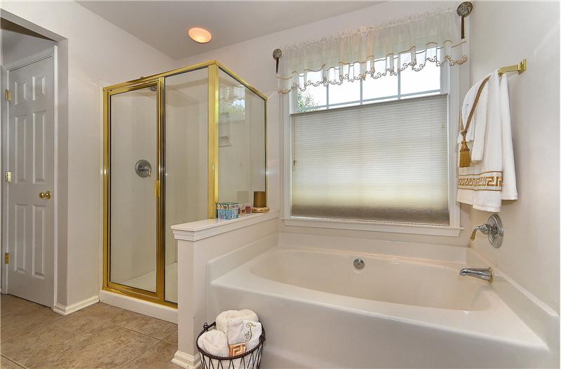 Glass enclosed, walk-in shower and garden tub complete this luxurious bathroom