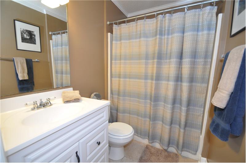 Master bathroom has neutral paint, custom cabinetry and tub/shower combo