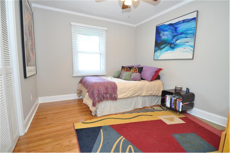 Second bedroom is spacious with hardwoods, neutral paint & ceiling fan