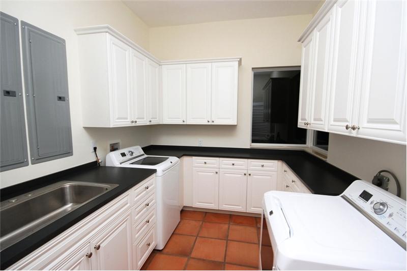 Spacious utility room equipped with full size cabinets, washer dryer and soak sink.
