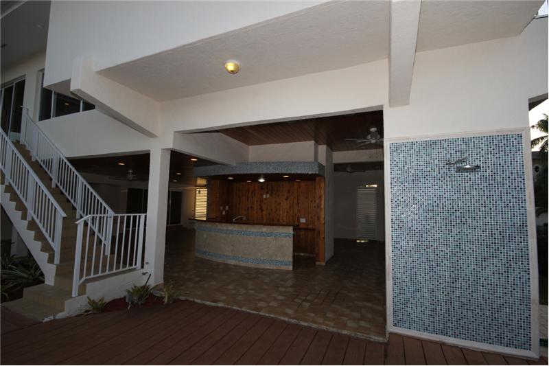 Expansive summer kitchen living space on 1st floor by pool and views of waterway.